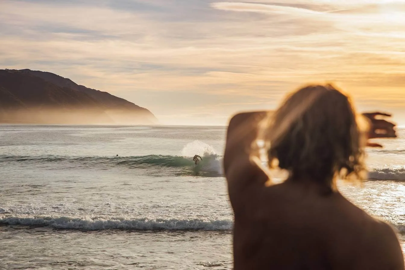 Man looking into surf at surfer in Kaikoura