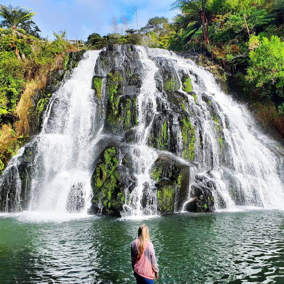 person standing in front of a waterfall in Karangahake Gorge