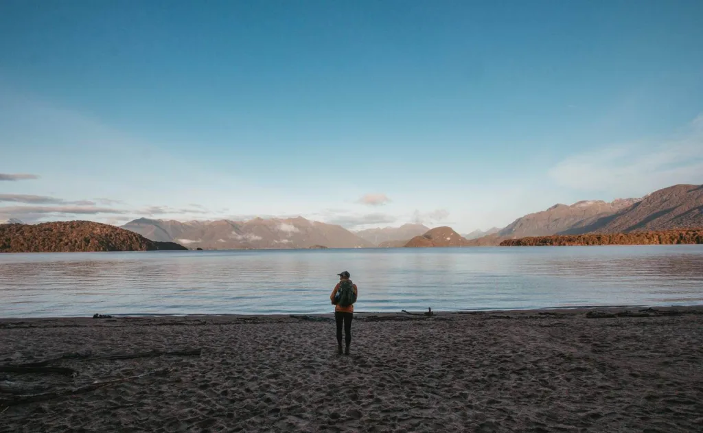 Kepler track, person stood on beach in front of lake