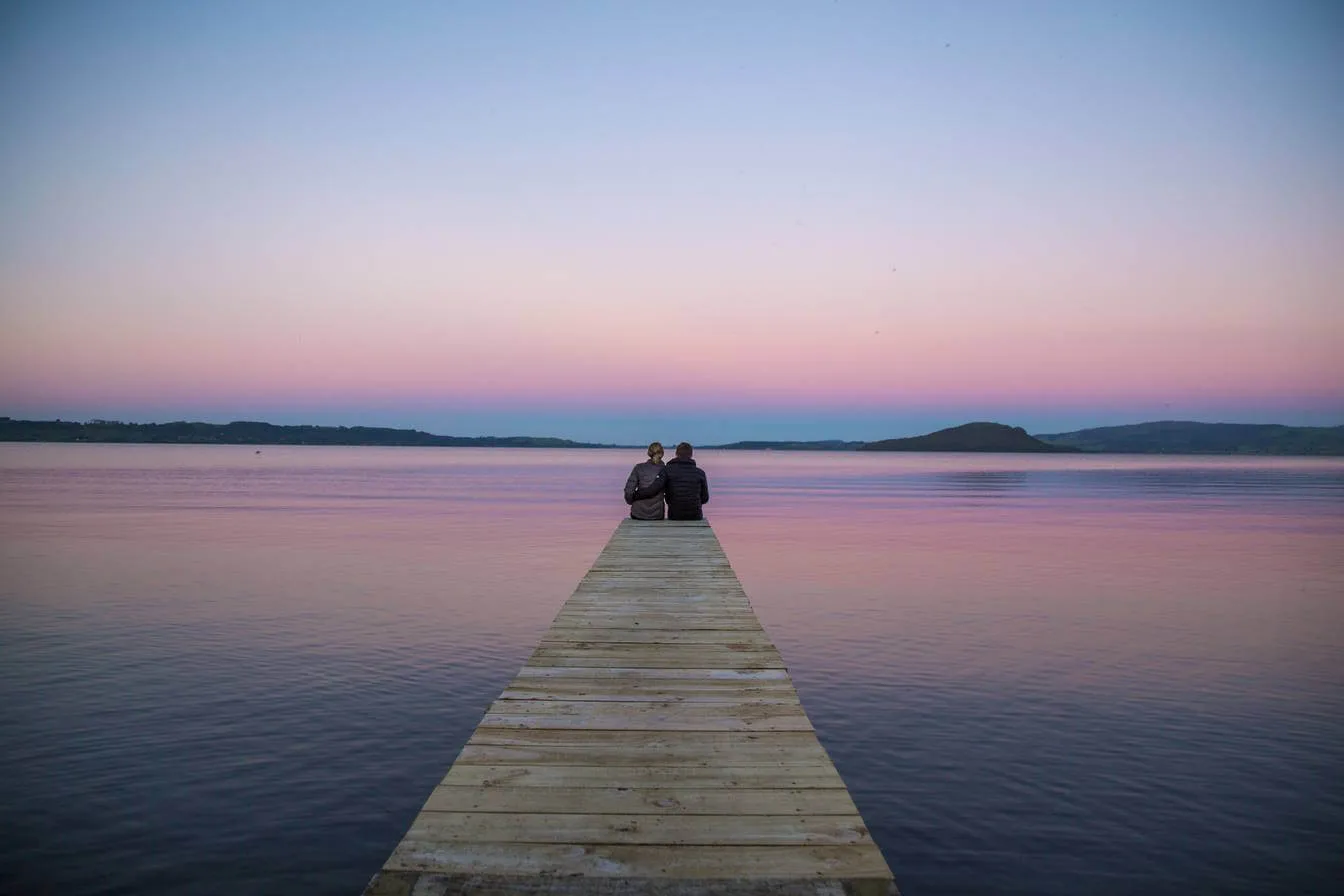 Couple on pier at sunset